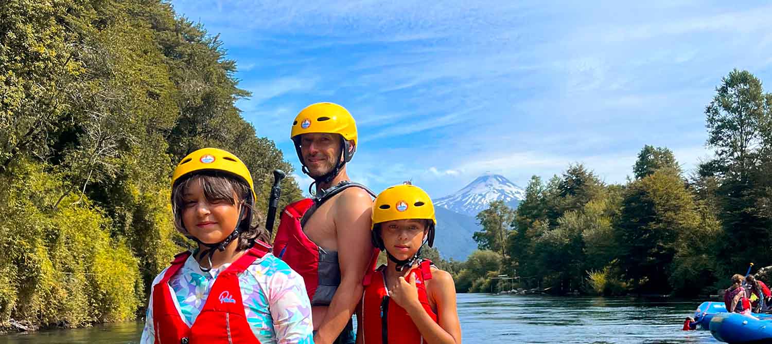 Familia con cascos y chalecos frente al volcán