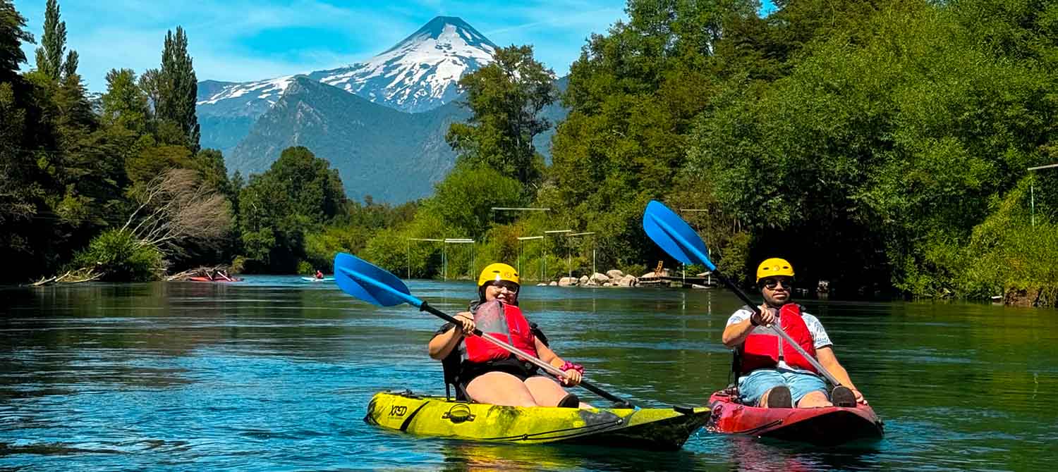 Kayakistas con el volcán nevado de fondo